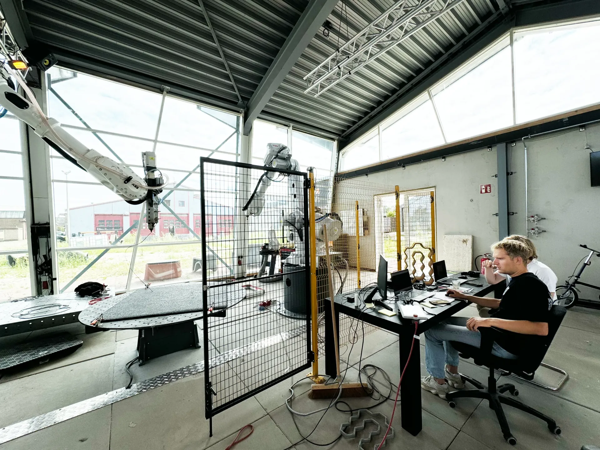 Robotic arm printing large-format polymer structure in workshop